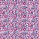 Pink and blue sprinkle mix with white pearls, pink flower pieces, and blue candy-coated beads on a light pink base.