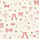 A close up of fabric patterned with pink bows and coffee beans on a cream background. 