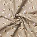 Fabric patterned with dots and espresso martinis on a taupe background. It has been carefully folded to show the weight of the fabric. 
