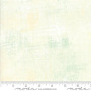 A fabric swatch featuring a soft tonal print. The primary color is off white, with a blend of soft green and cream. There is a ruler at the bottom for scale. 