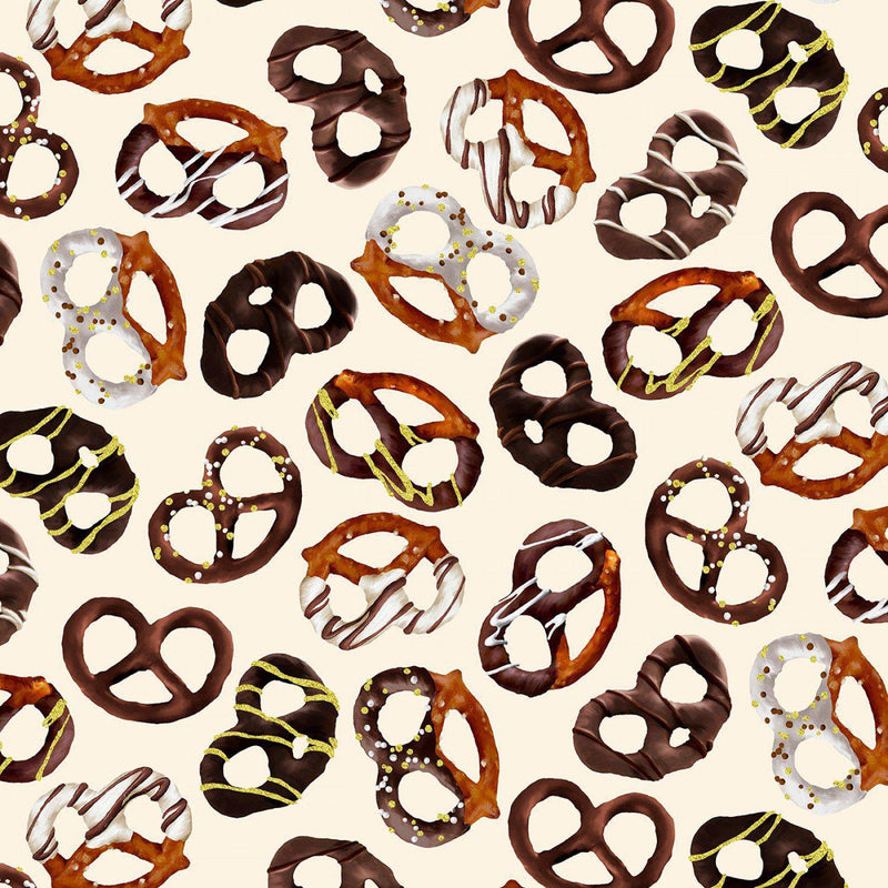Fabric with a repeating pattern of tossed chocolate pretzels on a cream background.