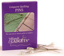 A package of handiquilter longarm quilting pins. The long pins have pear shaped pearlized heads. The purple packaging is photographed next to the pins on a white background