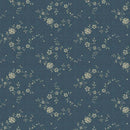 A close-up of a blue fabric or wallpaper pattern featuring a repeating design of small cream-colored flowers and delicate green leaves on a textured blue background.