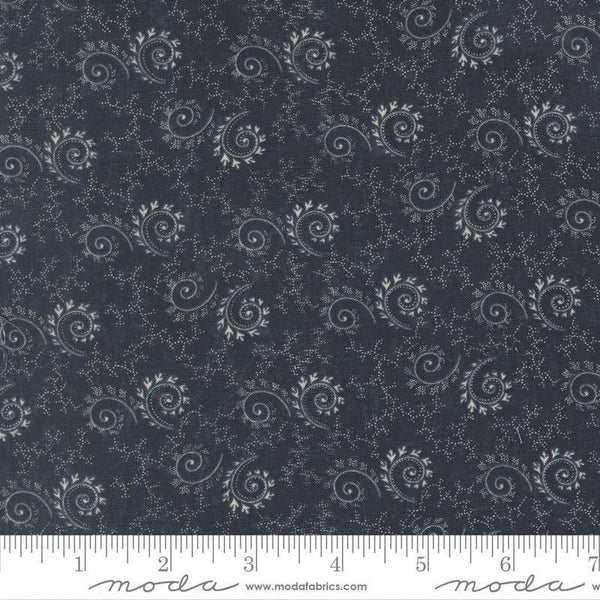 Patterned fabric with paisley design on a dark blue background, featuring a ruler at the bottom for scale.