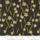 Fabric patterned with white and yellow daffodils on a black background. The gold pictured in the swatch is metallic. There is a ruler at the bottom for scale.