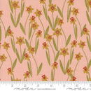 Fabric swatch patterned with yellow daffodils on a pink background with a ruler at the bottom for scale. The gold in the image is metallic. 