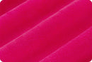 A close up of diagonally folded bright pink plush fabric