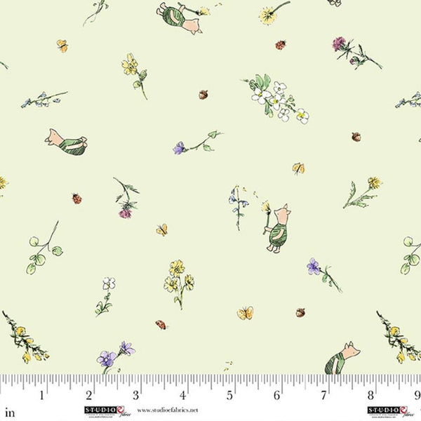 Fabric with cartoon characters and flowers on a light green background, ruler at the bottom for scale.