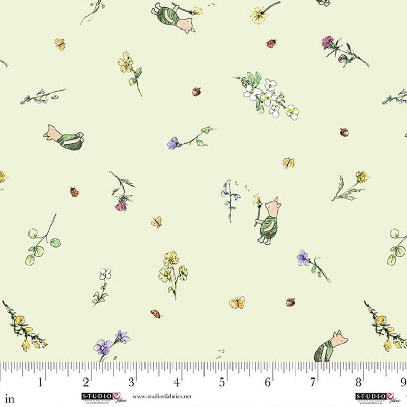 Fabric with cartoon characters and flowers on a light green background, ruler at the bottom for scale.