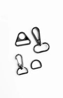the included hardware set in the quick boxy pouch kit on a white background, including a d ring and two hooks. 