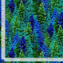 A fabric swatch featuring stylized evergreen trees in bright blue, teal, and green with small metallic gold accents. There is a ruler along the left and bottom edge to show scale.