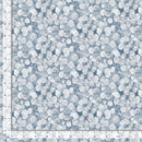 Fabric patterned with small white leaves on a light blue background with a ruler for scale 