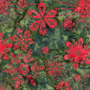 A batik fabric featuring red snowflakes tossed on a green tie-dye style background. 