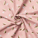 Fabric swatch featuring tossed martini glasses on a pink background. The fabric is folded to better show the drape